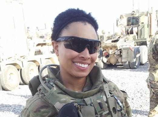 A woman in military uniform smiling for the camera.